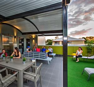 a group of people sitting around tables on a patio at Breeze Lodge in Brisbane