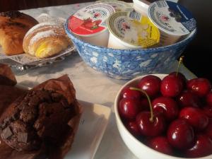 stół z miską wiśni i miską chleba w obiekcie B&B Smile w mieście Fiorano Modenese +26 zdjęć