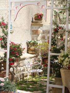 une chaise blanche assise dans un jardin fleuri dans l'établissement Guest House Al Gattopardo, à Favignana