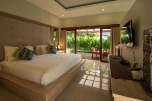 a bedroom with a large bed and a balcony at Living Asia Resort and Spa in Senggigi