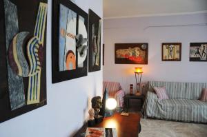uma sala de estar com um sofá e pinturas na parede em House of Arts em Pélla