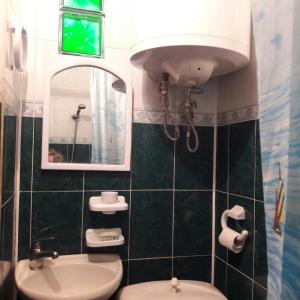 a bathroom with a sink and a toilet and a mirror at Dom on the seaside in Zatoka +16 photos