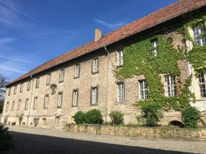 a large brick building with green ivy on it at Kloster Hedersleben in Hedersleben