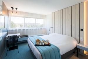 a bedroom with a bed with a tray with teddy bears on it at Opéralia Hôtel les Pins in Balaruc-les-Bains