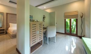 a bedroom with a desk and a bedroom with a bed at Living Asia Resort and Spa in Senggigi