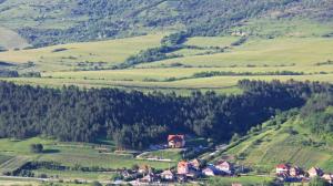 a village in the middle of a green hill at Pensiunea Armonia in Nădăşelu