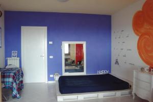 カスタニェート・カルドゥッチにあるMonolocale in residence con Piscinaの青い壁のベッドルーム(ベッド付)