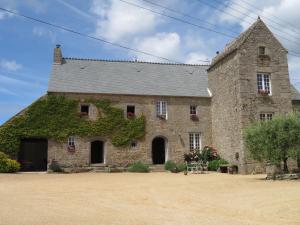 an old stone building with ivy on it at Manoir de Herclat in Néville-sur-Mer