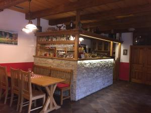um restaurante com uma mesa de madeira e um bar em Pension Mandl em Řetová