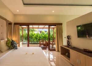 a bedroom with a large bed and a television at Living Asia Resort and Spa in Senggigi