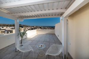 a balcony with chairs and a view of the city at Artemide Hotel in San Vito lo Capo
