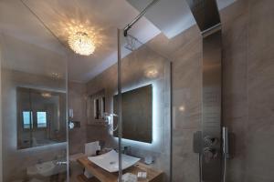 a bathroom with a shower and a sink and a mirror at Artemide Hotel in San Vito lo Capo