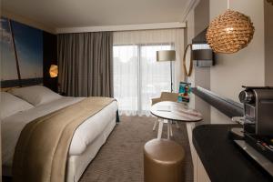 a hotel room with a bed and a table at Thalazur Arcachon in Arcachon