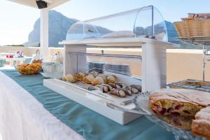 a table with some bread and pastries on it at Artemide Hotel in San Vito lo Capo