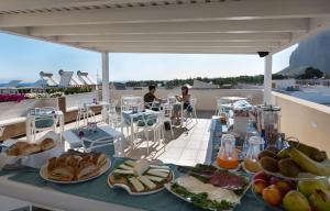 a table with plates of food on a roof at Artemide Hotel in San Vito lo Capo