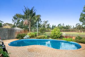 a small swimming pool in a yard with a fence at Coranda Lodge in Armadale