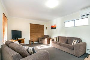 a living room with two couches and a flat screen tv at Coranda Lodge in Armadale