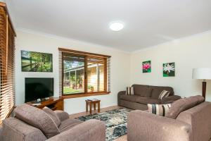 a living room with two couches and a flat screen tv at Coranda Lodge in Armadale
