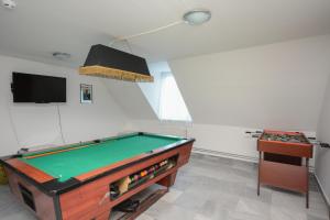 a room with a pool table and a tv at Hethland Zamárdi VSZ Üdülő in Zamárdi
