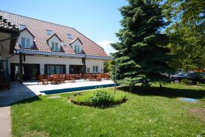 a house with a table and chairs in front of it at Hethland Zamárdi VSZ Üdülő in Zamárdi