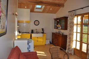 a kitchen with yellow cabinets and a counter top at Château Le Tour - Chambres d'Hôtes in Faux