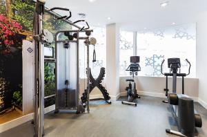 a gym with several tread machines in a room at Catalonia Giralda in Seville