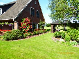 a red brick house with a yard with green grass at Schmidtfewo Moorgeist in Bockhorn