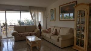 a living room with two couches and a table at Villa Jone in Diano Marina