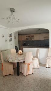 a dining room with a table and chairs and a kitchen at Villa Jone in Diano Marina