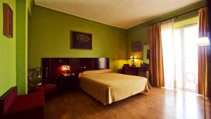 a bedroom with green walls and a bed and a window at Hotel Carlos V in Granada