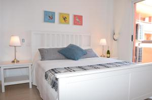 białe łóżko w białej sypialni z 2 lampami w obiekcie Albatros Playa 2 - 9408 w mieście Mar de Cristal +37 zdjęć