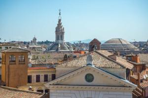 Blick auf eine Stadt mit einem Uhrturm in der Unterkunft Hotel Damaso in Rom