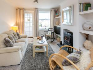 a living room with a couch and a fireplace at Walnut Cottage in Aldeburgh