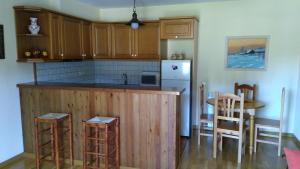 una cocina con armarios de madera y una mesa con sillas. en Apartamento Erta, en Pla de l'Ermita