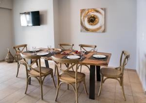 jadalnia z drewnianym stołem i krzesłami w obiekcie Pearl Mansions w mieście Nikiana