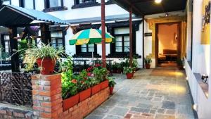 a porch of a house with an umbrella and flowers at Hotel Heranya in Kathmandu