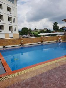a large swimming pool in front of a building at Pangviman Place Resotel SHA Plus in Chiang Mai