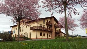 a building with balconies and trees in front of it at Sportpenzion Pohoda in Pilsen