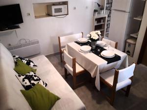a dining room with a white table and chairs at Holiday Home Mara in Tisno