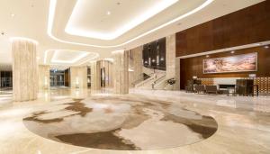 een lobby met een groot tapijt op de vloer bij Golden Lake Hotel in Jinhu