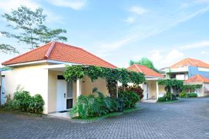 a building with a red roof on a street at Riverstone Hotel & Cottage in Batu