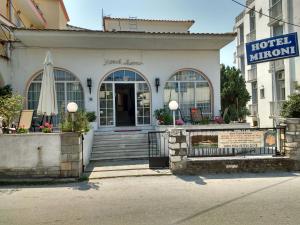 a hotel entrance with a building with a umbrella at Mironi & Victoria Hotel in Limenas