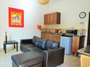 sala de estar con sofá y cocina en Kingfishers Apartments en Bijilo