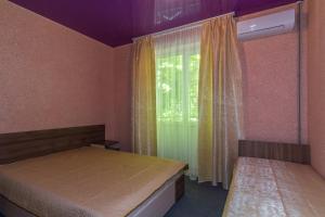 デデルコイにあるGuest House Triumphの小さなベッドルーム(ベッド2台、窓付)