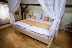 1 dormitorio con cama con dosel y cortinas blancas en Pension PREMIUM en Český Krumlov