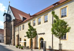 ein großes Gebäude mit einem Uhrturm auf einer Straße in der Unterkunft Augustinerkloster Gotha Herberge gGmbH in Gotha