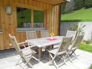 a wooden table and chairs on a patio at Ferienhaus Pfeifer in Gaschurn