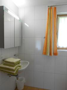 a white bathroom with a sink and a window at Ferienhaus Pfeifer in Gaschurn +13 photos