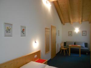Cette chambre comprend deux lits, une table et un canapé. dans l'établissement Ferienhaus Pfeifer, à Gaschurn