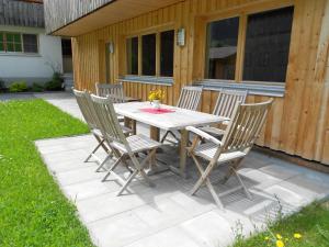 a wooden table with four chairs on a patio at Ferienhaus Pfeifer in Gaschurn